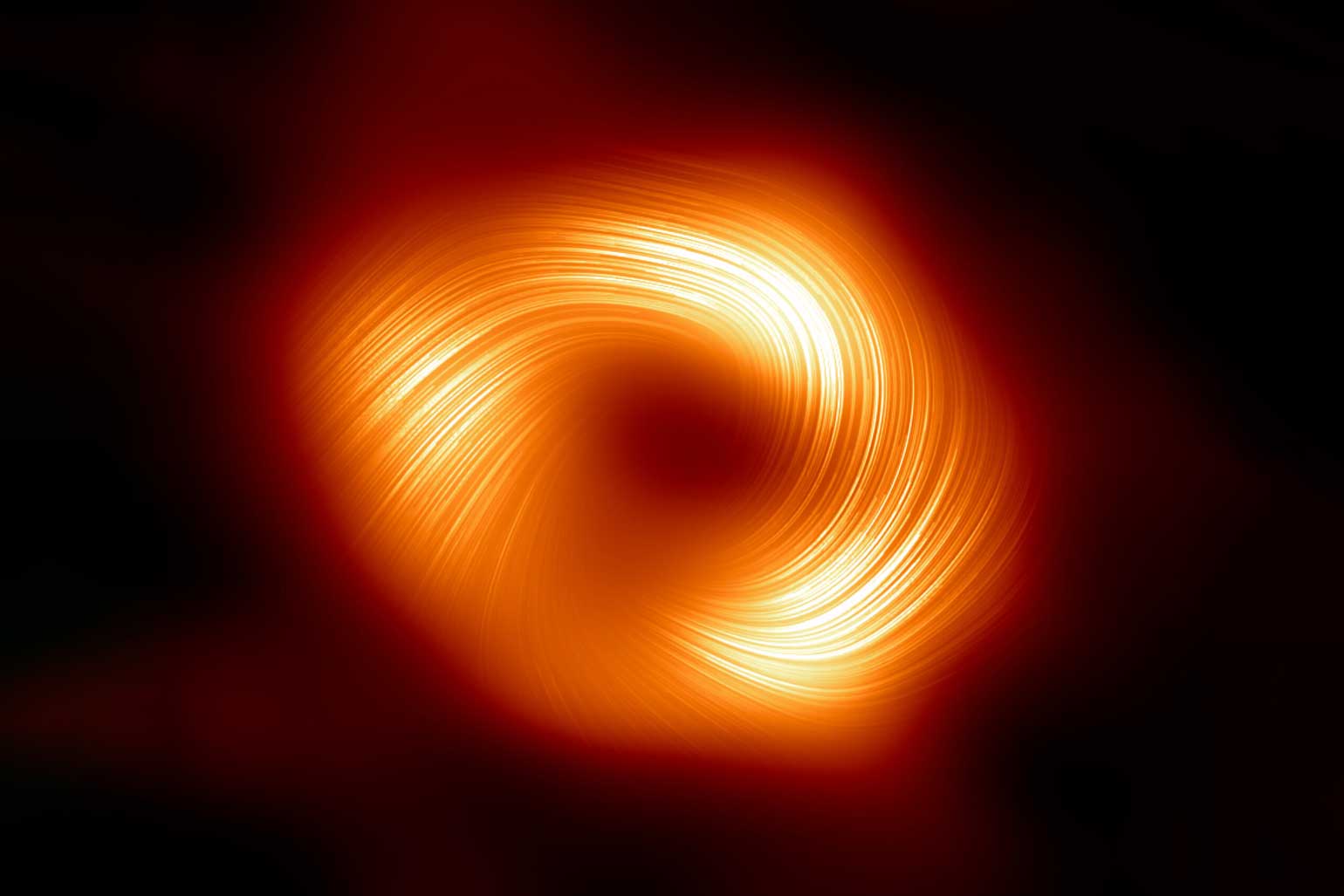 Strong magnetic fields spiraling at the edge of the Milky Way’s central black hole