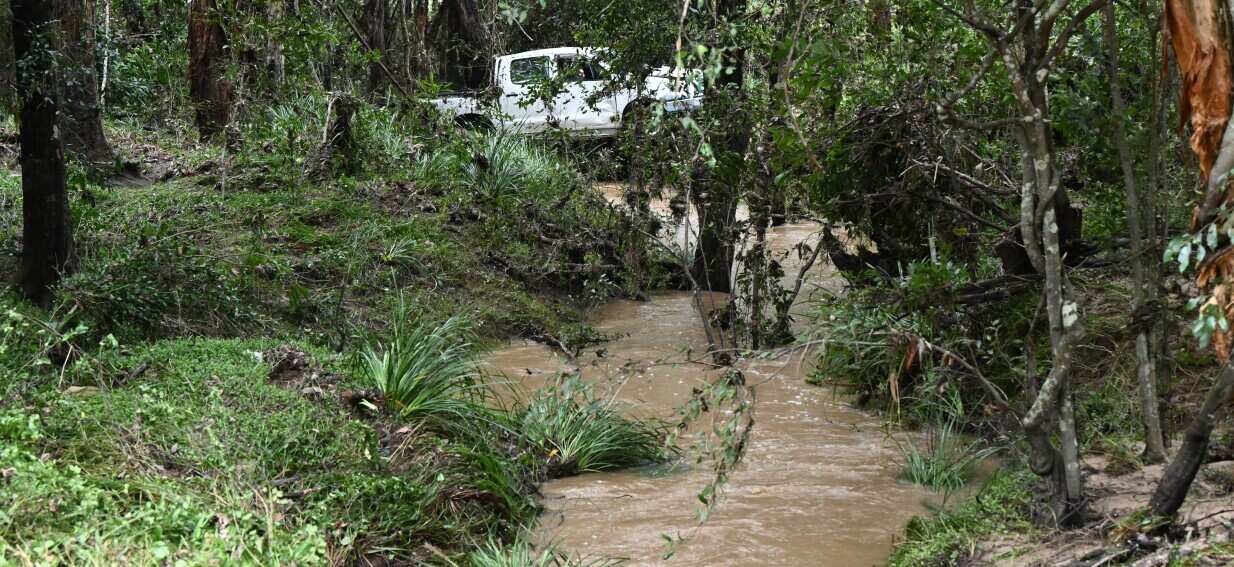 A man has died in Queensland floodwaters, as heavy rain lashes east coast